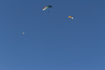 Paraplan and deltaplan in alps over a ski resort