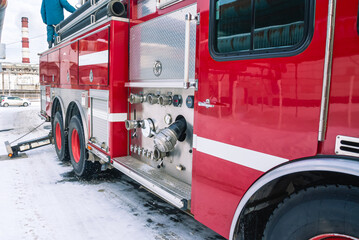 Fototapeta premium A fire truck for delivering firefighters to the fire site and supplying fire extinguishing agent for extinguishing in winter. Emergency rescue service. The control panel of the fire truck.