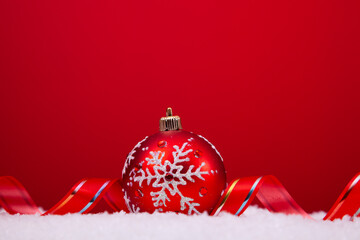 christmas colorful balls over the snow with a red background