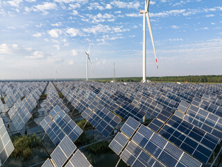 view of solar power station and wind turbine in field