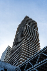 Obraz premium Modern Architectural Construction of a High-Rise Building Against a Clear Sky