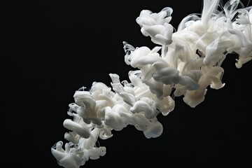 White ink in water on black background studio shot.