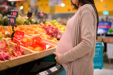 Beautiful pregnant woman shopping healthy food at grocery shop