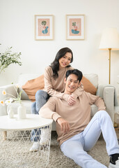 Portrait of young asian couple sitting in living room at home