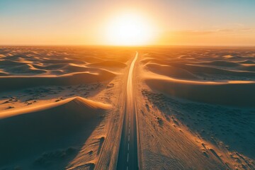 A serene desert landscape with a long road leading towards a vibrant sunset.