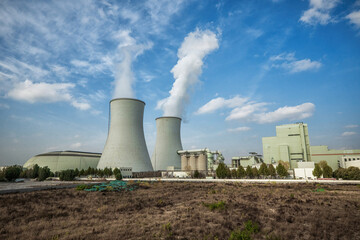 Cumulus Clouds Over Industrial Facility and Barren Ground