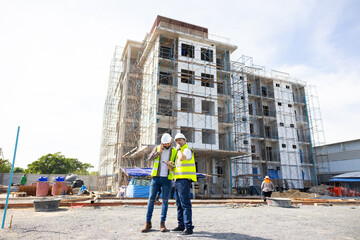 Fototapeta premium Architect and contractor working on building in construction site. Two Professional Architects Engineer Working on Personal laptop computer at house construction site