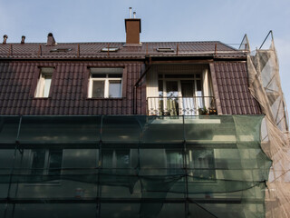 Scaffolding with protective mesh on building, facade restoration