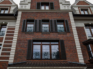 House with windows, finished facade facing brown brick