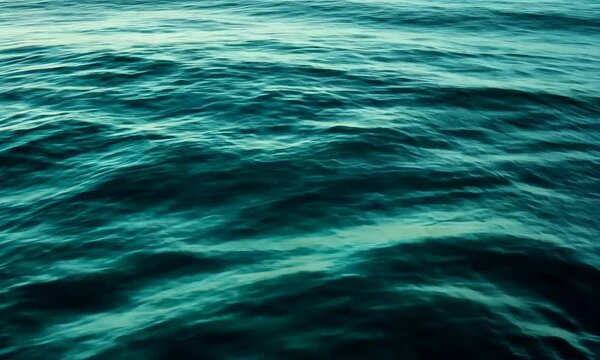 The deep blue waters of the ocean exhibit a dynamic texture, creating a sense of mystery and the vast, untamed nature of the sea