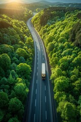 Aerial view of a hydrogen truck and car on a highway in a lush green forest landscape