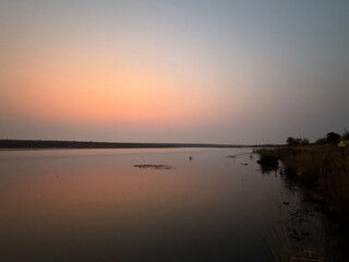 Blue and pink sky with reflection on the river, calm pink sunrise over the river in a safari