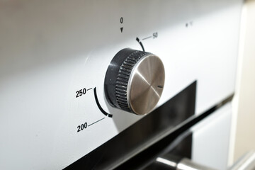 Round temperature control knob on a gas stove panel.