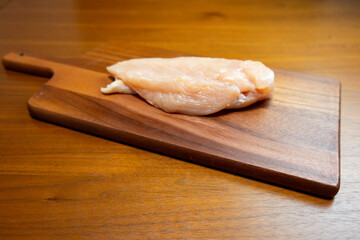 木製のカッティングボードの上の鶏むね肉