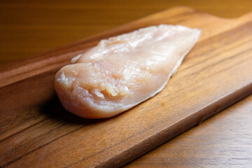 木製のカッティングボードの上の鶏むね肉