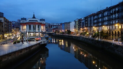 Northern spanish town's cityscape illuminated by city lights by evening