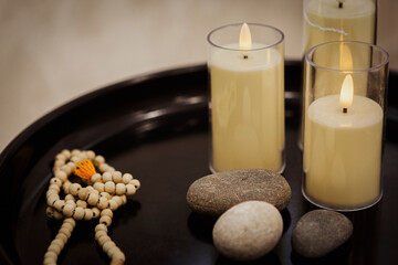 Atmospheric set of accessories in spa salon. Candles, stones and rosary, copy space, selective focus.