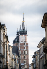 Historical street in old city center with huge tower on its end, Krakow, Poland