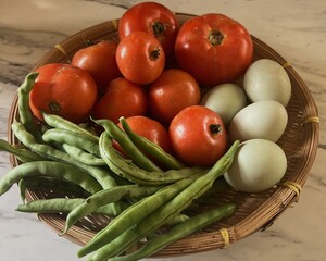 Close up of Basket of local produce from farmers market, green beans, tomatoes and duck eggs
