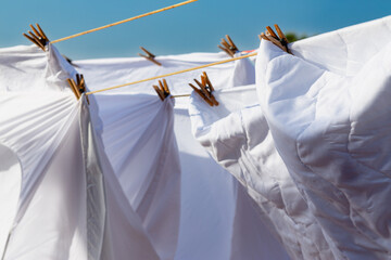 Murcia, Spain - 12th August 2024 - White laundry drying in sunlight against a clear blue sky, creating a vibrant atmosphere during a summer day