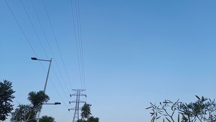 A clear blue sky with a few power lines and a street light