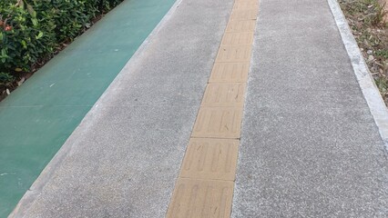 A grey and brown sidewalk with a green border