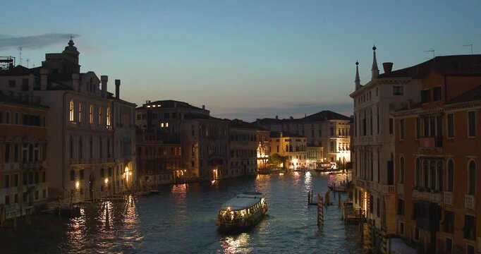 Evening boat journey through the illuminated canals of Venice under the serene twilight sky