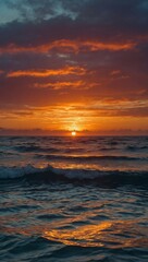 A vibrant sunset casting its colors over calm ocean waves.