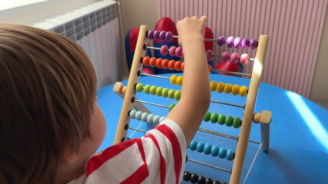 A child boy toddler is playing with children's abacus, counter or settled accounts.