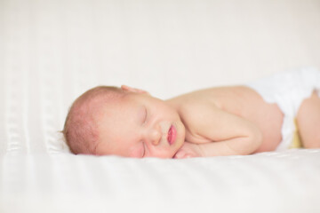 Little baby on white bed