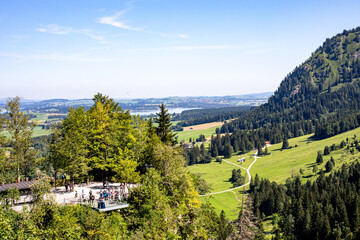 Scenic overlook showcasing lush greenery and distant lake views in a mountainous area during a...