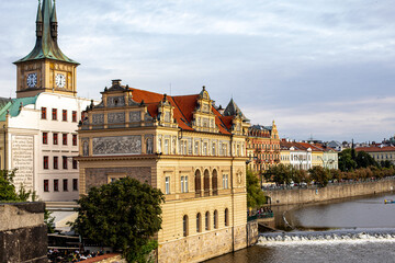 Historic architecture along the riverbank in Prague at sunset, showcasing stunning buildings and serene water reflections