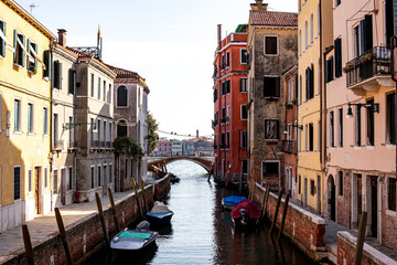 Exploring the picturesque canals of Venice with colorful buildings and small boats under a clear sky in the afternoon