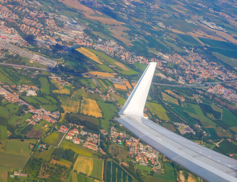 Fototapeta breathtaking aerial view from the window of an airliner and you can also see a piece of the wing and the fields and houses