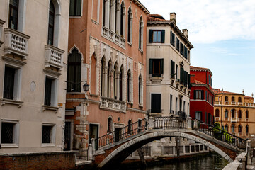 Charming canal view with traditional Venetian architecture and an arched stone bridge during a sunny day in Venice