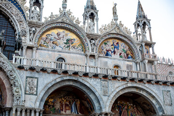 Beautiful architectural details of St. Mark's Basilica at dusk showcasing intricate mosaics and sculptures in Venice, Italy