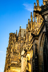 Stunning view of St. Vitus Cathedral's intricate architecture against a clear blue sky in Prague...