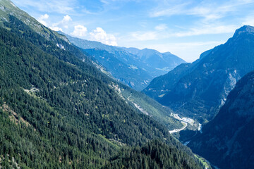 Breathtaking view of lush green valleys and majestic mountains in the Swiss Alps under a clear blue sky during summer