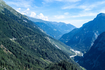 Fototapeta premium Stunning panoramic view of lush green mountains and valleys under a clear blue sky in the daytime