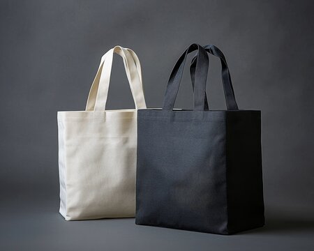 Tatami Texture A Study in Contrasts Two tote bags one white and one black stand sidebyside against a gray backdrop showcasing the unique texture of their fabric Tote bag