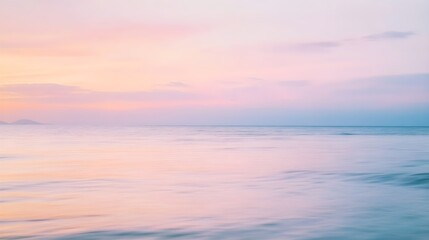 Obraz premium A blurred seascape at sunrise with soft pastel colors blending into the horizon, conveying a sense of tranquility