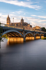 Obraz premium View of Salamanca (Spain) at sunset, with the cathedral and the Enrique Estevan bridge from the viewpoint of the pier on the Tormes river