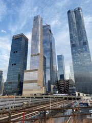 Obraz premium New York city skyscrapers, new buildings with glass reflections. Small clouds, blue skies