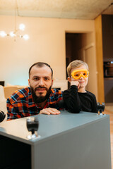 Father and son assembling furniture together at home