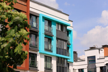 City view on a sunny day. Modern building and houses against the blue sky.