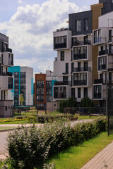 City view on a sunny day. Modern building and houses against the blue sky.