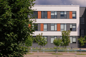 City view on a sunny day. Modern building and houses against the blue sky.