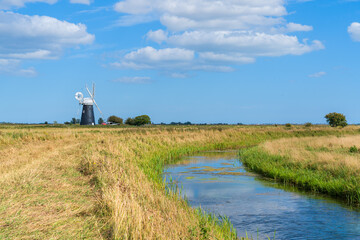 Halvergate Windmill in the Norfolk Broads National Park in the UK in landscape orientation from a distance with Halvergate marshes