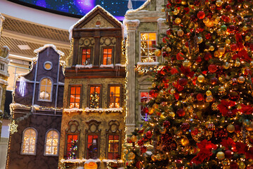 New Year's decorations, toys and garlands on the windows in fabulous scenery. Houses for children in a public place. Background for design. 