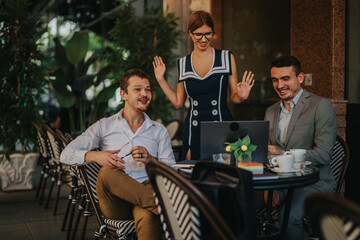 Businesspeople gather outdoors at a cafe, sharing ideas and collaborating in an engaging meeting, bringing enthusiasm and teamwork to the project.